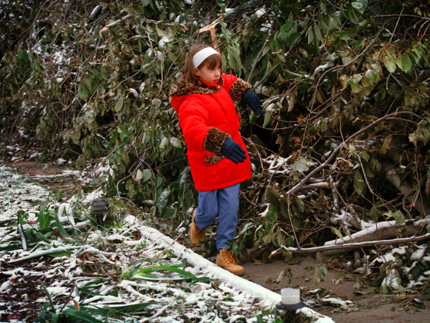 Emily Wall 8, works her way through a maze of storm debris along the sidewalk near 55th and Marcy on her way to Washington School Monday morning. Omaha Public Schools have been closed since a snow storm left downed power lines and trees.